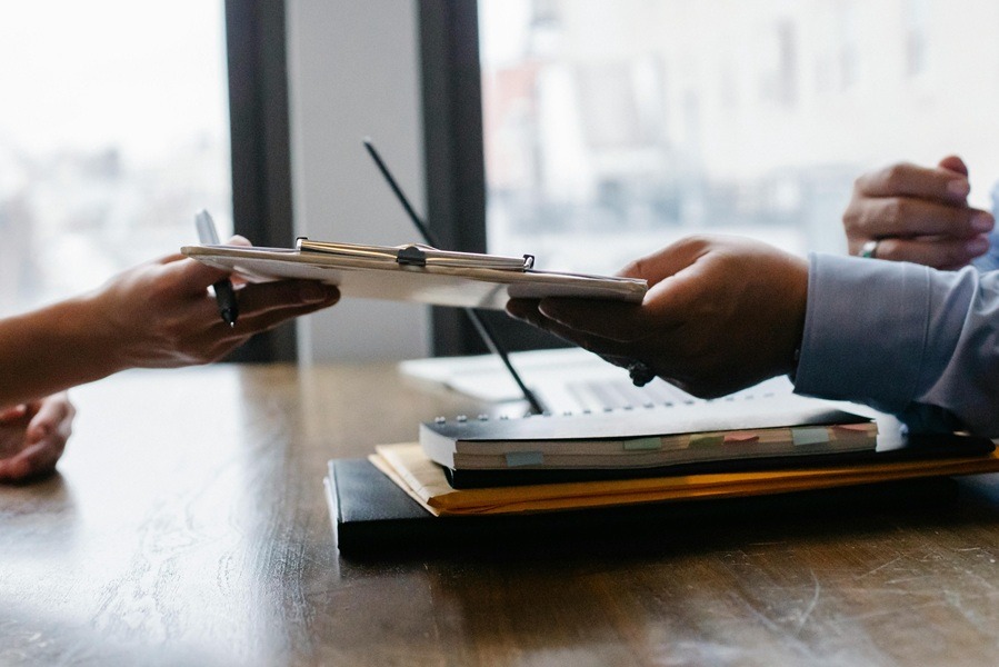 A professional handshake between two individuals in a formal office setting, symbolizing a business agreement.